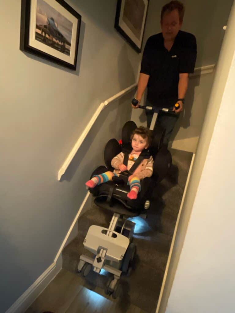 young disabled girl comes downstairs using stairclimber