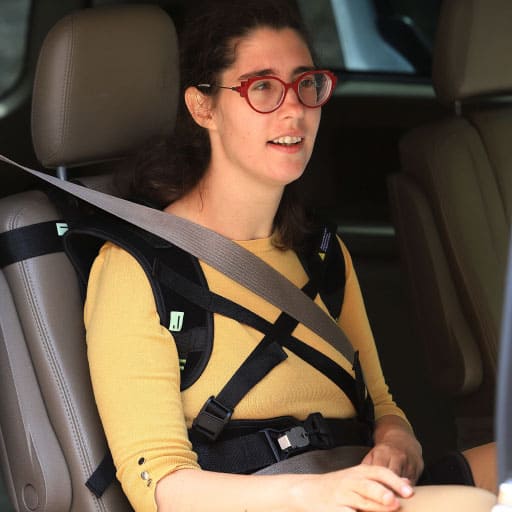 disabled girl sits upright using Voyageur safety harness