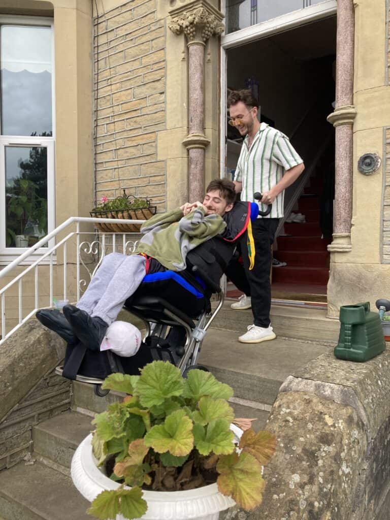 carer takes disabled man down outside steps with a stairclimber