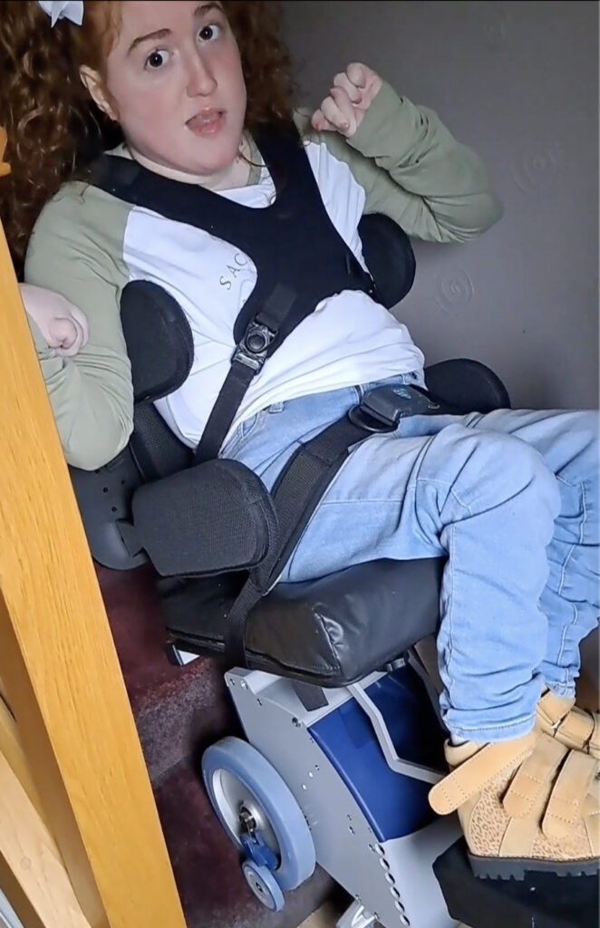you girl with disabilities is sat on a stairclimber