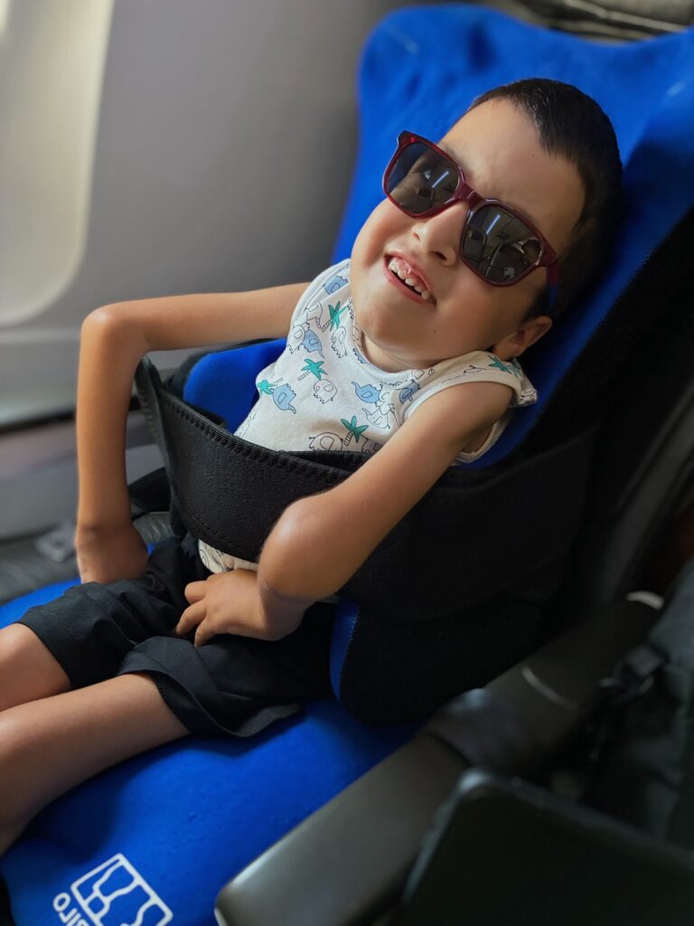 disabled boy sits comfortably on an aeroplane using a vacuum posture cushion
